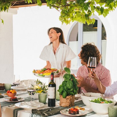 Tavola apparecchiata con vini Doppio Passo e piatti tipici italiani.